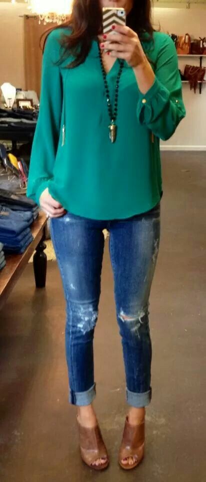Teal blouse with long pendant necklace + distressed jeans + cognac .